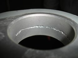 Corrosion in the pintle pin bushing boss of the MLG casing.